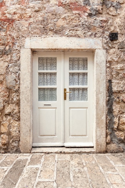 Alte weiße klassische Tür im alten Steingebäude