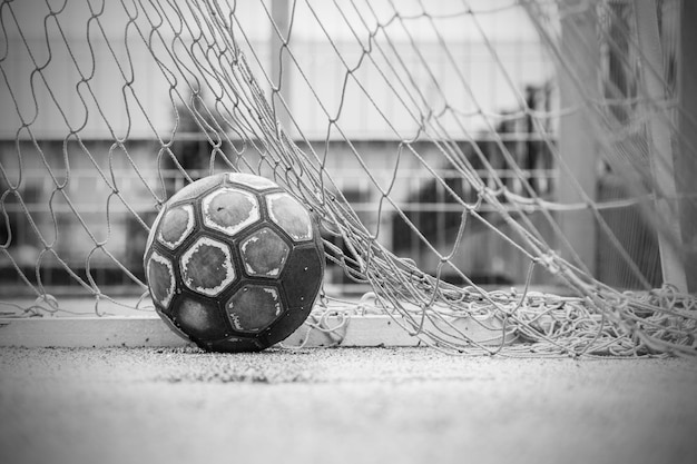 Alter abgenutzter Lederball in einem Tor