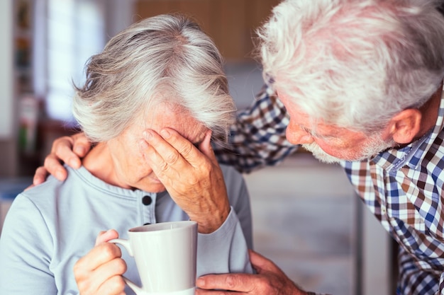 Alter älterer Mann, der seine Frau mit depressiver Krankheit tröstet Unglückliche ältere Frau zu Hause braucht medizinische Hilfe Ourmindsmatter