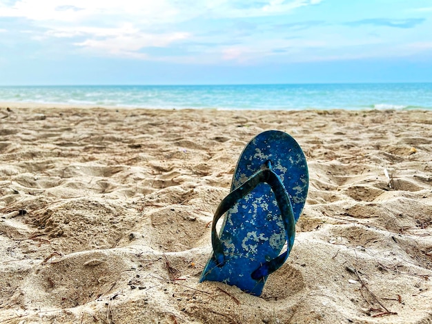 Alter blauer Sandalenmüll am Strand an der Sommerküste