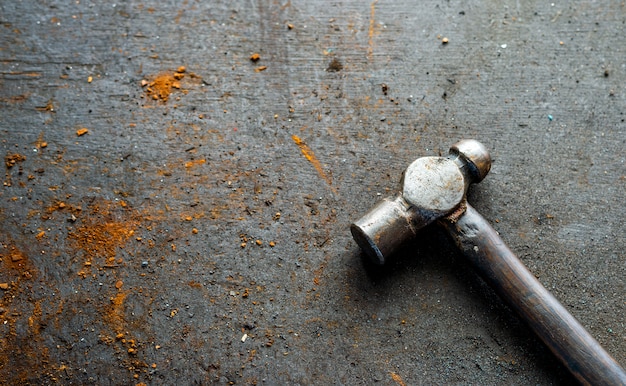 Alter Eisenhammer auf Holz mit Weichzeichnung und über Licht im Hintergrund. Draufsicht