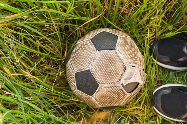 Alter Fußball auf dem grünen Gras, Draufsicht.