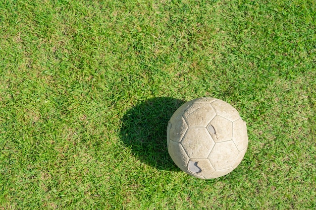 Alter Fußball auf grünem Gras des Fußballfeldes. Vintage Fußball.