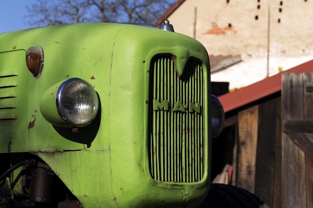 Alter grüner Oldtimer-Traktor steht auf dem Hof