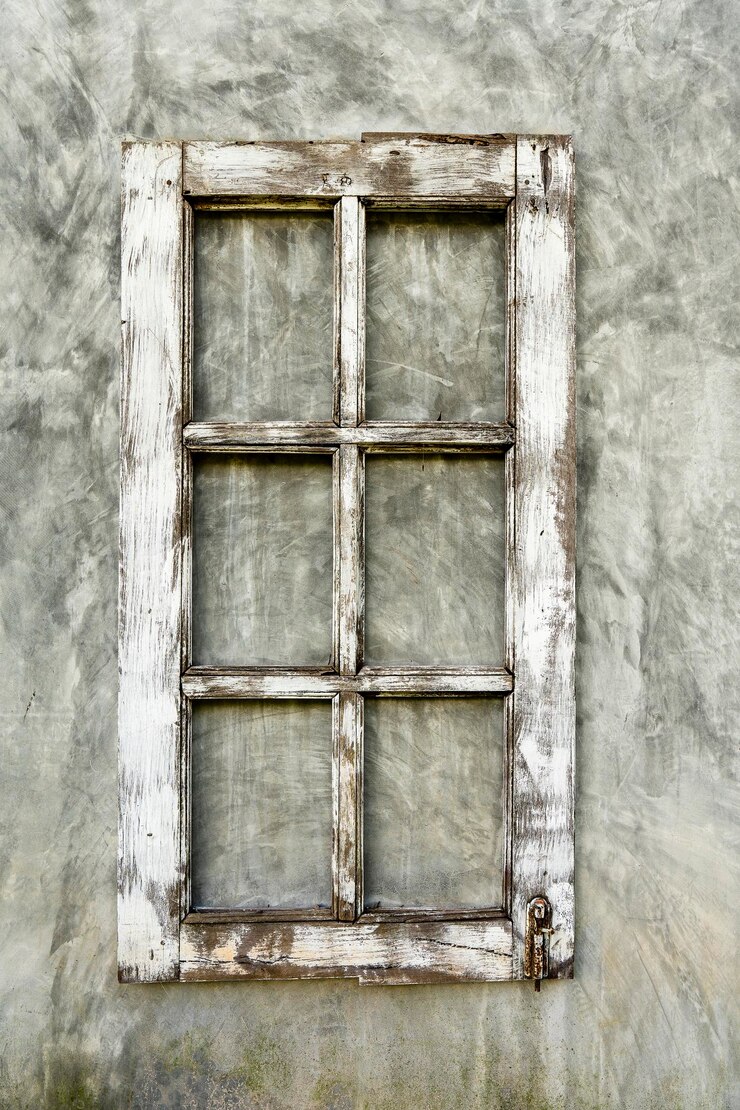 Alter Holzrahmen aus einem Fenster an einer verputzten Wand
