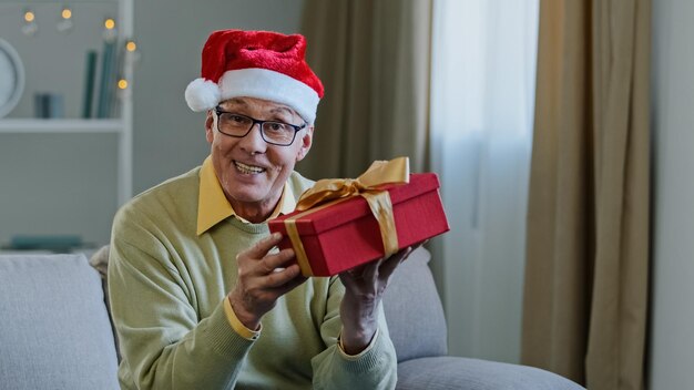 Alter kaukasischer älterer reifer Mann Großvater in Sankt-Weihnachtsmütze zu Hause singen Liedtanzen