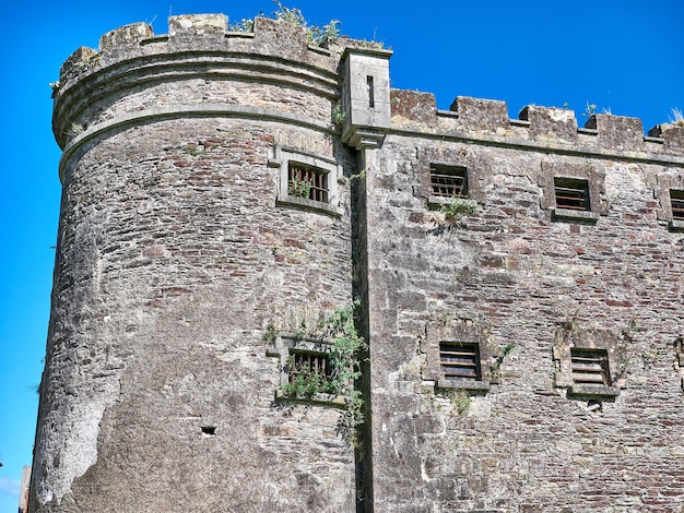 Alter keltischer Burgturm und ein Haus Alte irische Architektur Hintergrund