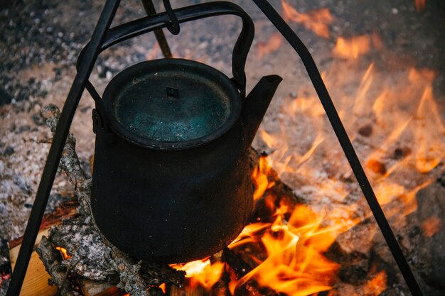 Alter Kessel ist brennender Stange, Touristen kochen Wasser