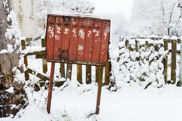 Alter klappriger Briefkasten im Winter unter dem Schnee