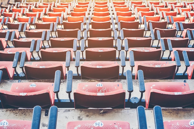 Foto alter leerer roter stadionstuhl im stadion.