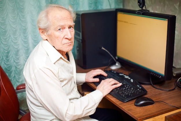 Alter Mann, der am Computer arbeitet