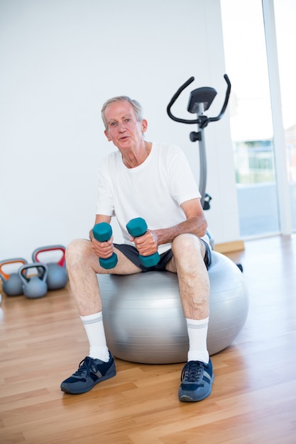 Alter Mann, der auf Übungsball sitzt