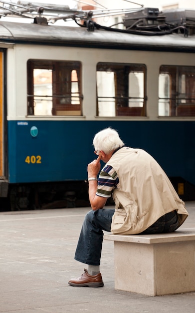 Alter Mann, der eine Tram schaut