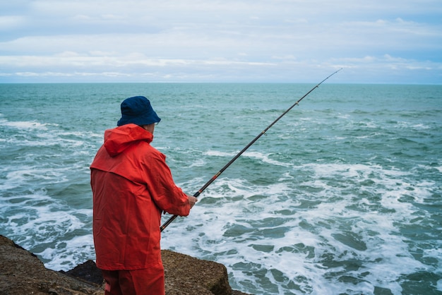 Alter Mann, der im Meer fischt.