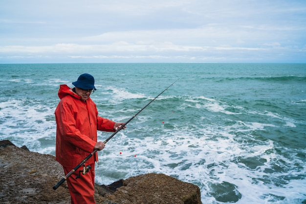 Alter Mann, der im Meer fischt