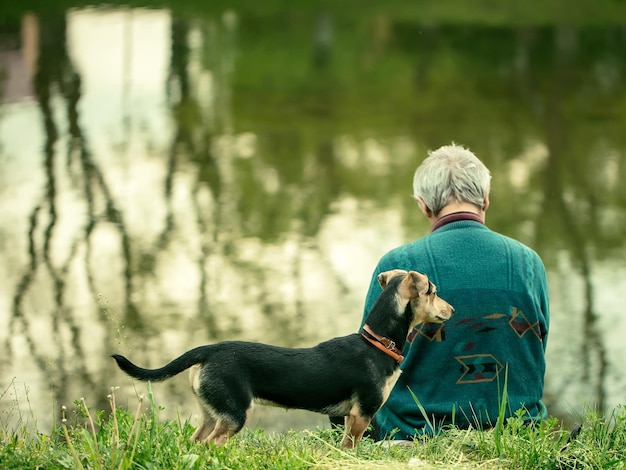 Alter Mann mit Hund nahe Wasser