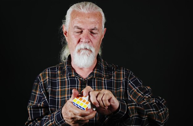 Alter Mann spielt mit Rubiks Cube Game Photo