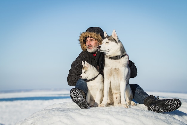 Alter Mann und Schlittenhunde auf einer Eisscholle.