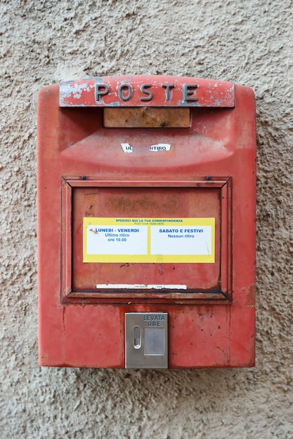 Foto alter roter briefkasten an einer grauen hauswand