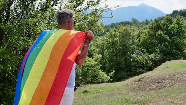 Alter schwuler Mann geht mit LGBTQIA-Friedensflagge