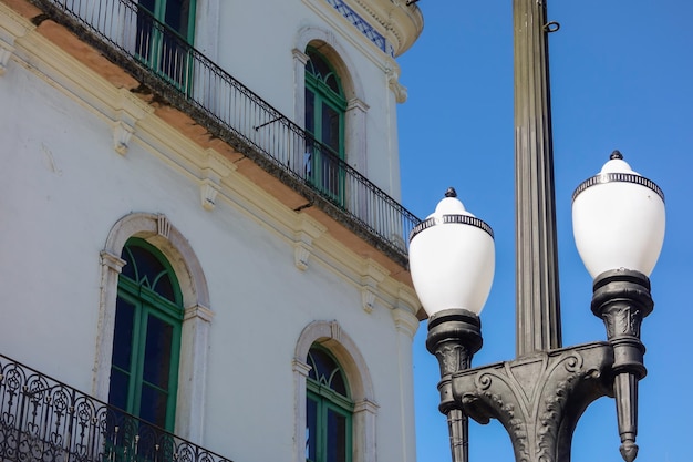 Alter Straßenmast mit Lampen und alter Architektur im Hintergrund