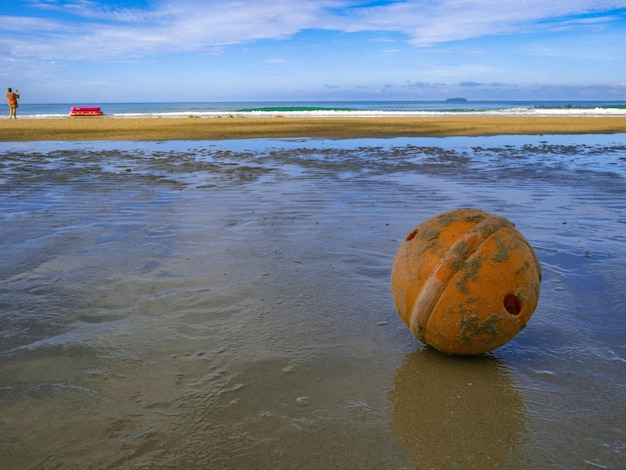 Alter und schmutziger Bojenball am Strand