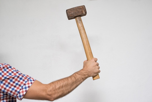 Foto alter vorschlaghammer in der hand eines mannes. weißer hintergrund