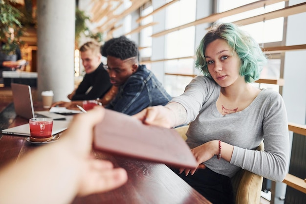 Foto alternatives mädchen mit grünen haaren sitzt gegen eine gruppe multiethnischer menschen