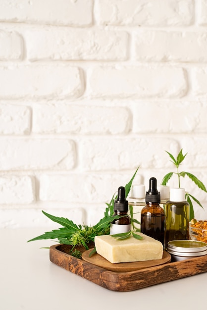 Alternativmedizin, Naturkosmetik. CBD-Öl und Cannabis hinterlässt Kosmetika-Vorderansicht, Kopierraum, Mock-up-Design