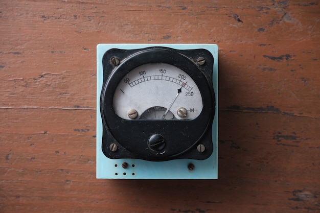 Foto altes analoges voltmeter mit einem metallpfeil. messung der spannung im stromnetz.