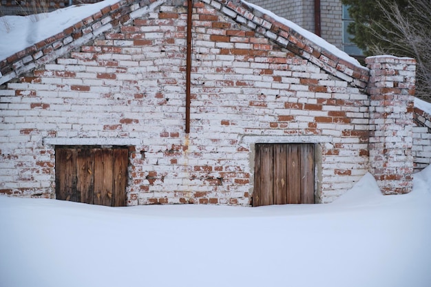 Altes Backsteinhaus ist bis zu den Türen mit Schnee bedeckt