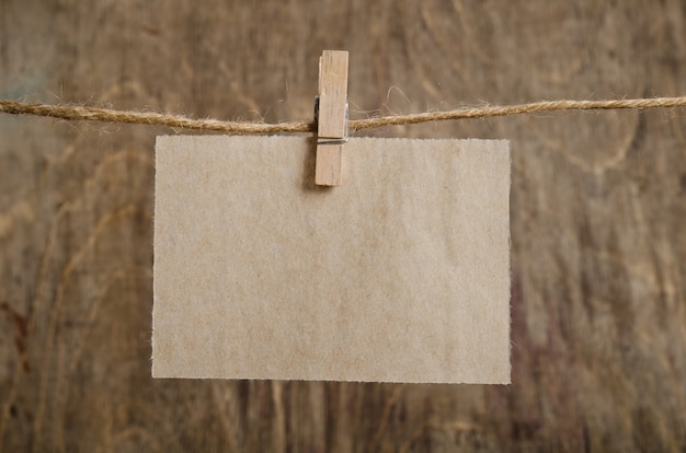 Foto altes blatt papier, das an der wäscheleine auf wäscheklammer hängt