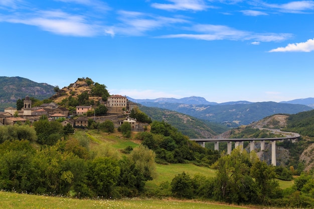 Altes Dorf und moderne Brücke in den Bergen vor einem blauen bewölkten Himmel Toskana Toscana Region Italien Konzept der Antike und Moderne