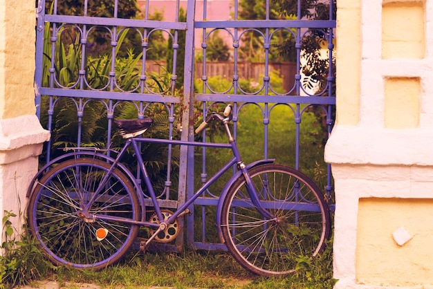 Altes Fahrrad am Zaun geparkt