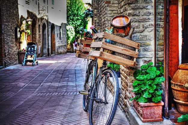 Altes Fahrrad mit Holzkiste gegen eine Mauer in San Gimignano Italien