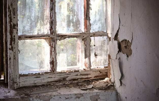 Altes Fenster mit schäbiger rissiger Farbe