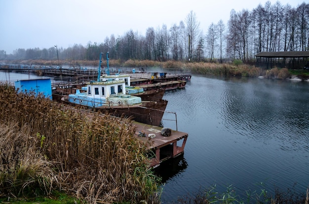 Altes Fischerboot vor Anker am Pier Rusty Iron Ship Dump auf dem Fluss oder einem anderen Stausee Gebrauchte und aufgegebene Fischereiausrüstung