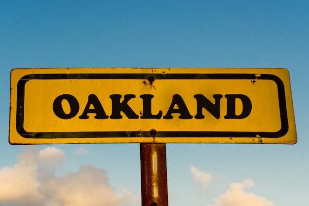 Altes gelbes Schild der Stadt Oakland mit blauem Himmel