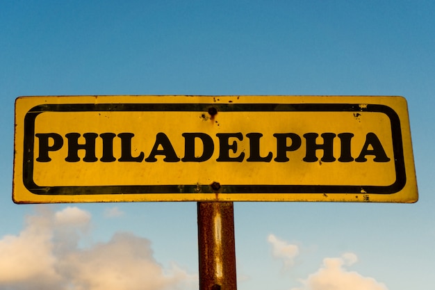 Altes gelbes Schild der Stadt Philadelphia mit blauem Himmel