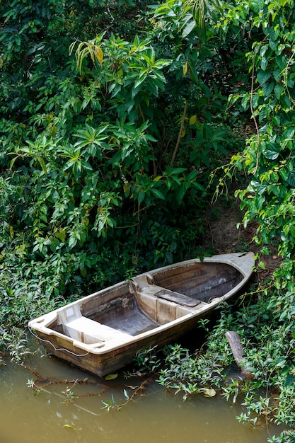 Altes Glasfaserboot verankert am Ufer des Flusses