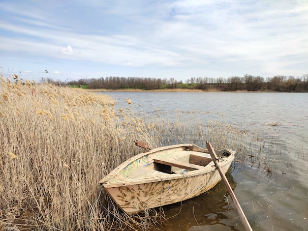 Altes hölzernes Fischerboot an Fluss- oder Teichküste