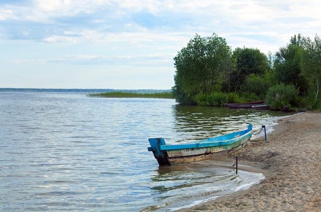 Altes hölzernes Fischerboot in der Nähe des Sommerseeufers (Svityaz, Ukraine)