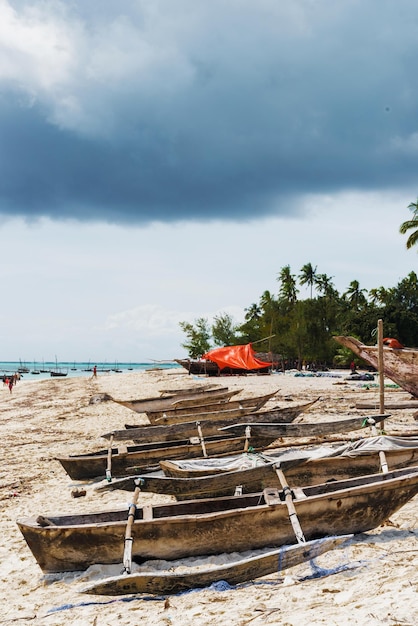 Altes hölzernes Fischerboot mit Ruder am afrikanischen Strand in der Nähe eines Dorfes