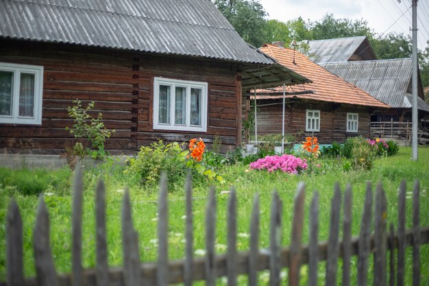 Altes hölzernes ländliches Haus in einer bergigen Gegend in den Karpaten. Traditionelles Gebäude. Hof mit grünem Gras.