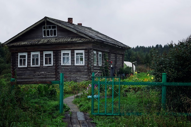 Altes Holzblockhaus mit Gemüsegarten im Dorf.