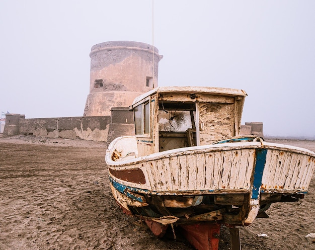 Altes kleines verlassenes Schiff mit einem Turm im Hintergrund