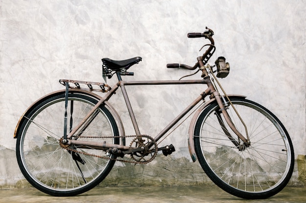 Altes rostiges Weinlesefahrrad nahe der Betonmauer