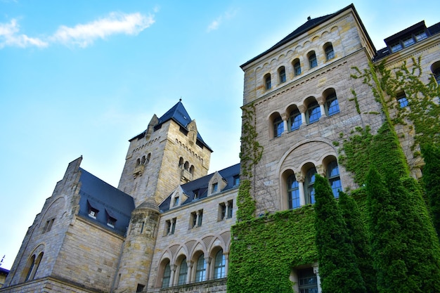 Altes Schloss aus grauem Backstein mit Türmen, hohen Fenstern und blauem Dach, Polen, Posen