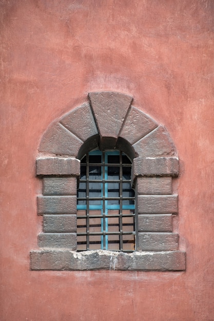 Altes Steinfenster im Schloss. Metallstangen am Fenster. Vertikaler Rahmen