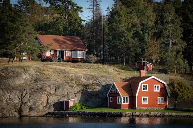 Altes traditionelles rotes Fischersommerhaus im schwedischen skandinavischen Hintergrund